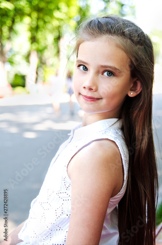 Fototapeta Naklejka Na Ścianę i Meble -  Portrait of adorable smiling little girl child schoolgirl teenager outdoors