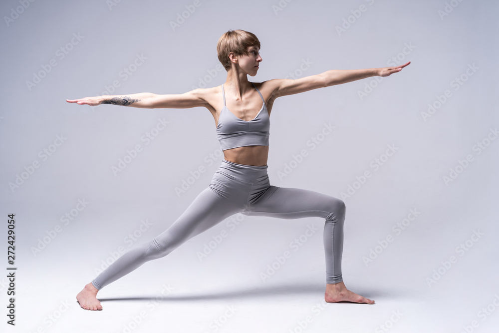 Fototapeta premium Young attractive Woman practicing home yoga, working out, wearing sportswear. Healthy life, keep fit concepts.