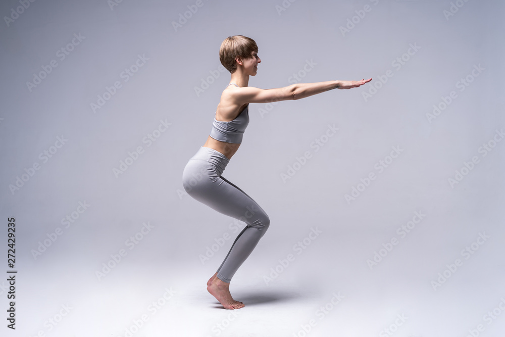 Obraz premium Young attractive Woman practicing home yoga, working out, wearing sportswear. Healthy life, keep fit concepts.