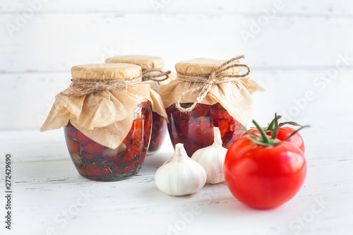 Tomatoes in the jar. Homemade sun dried tomatoes. temporary closing-down. Summer and autumn canned food. conserve with spices and vegetables. photo