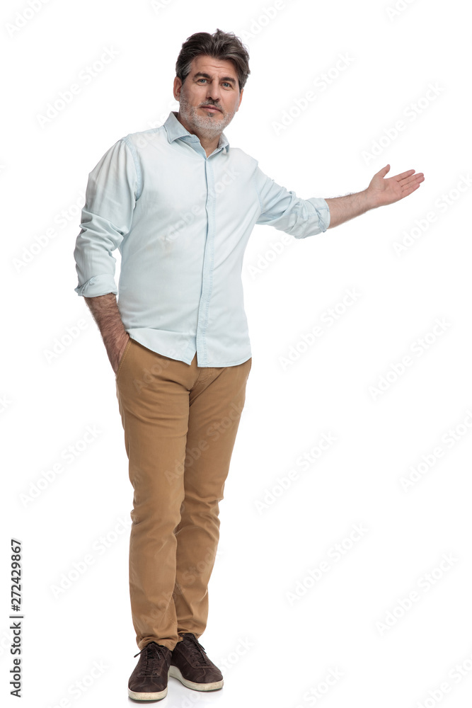 Casual man presenting and holding his hand in his pocket Casual man presenting and holding his hand in his pocket