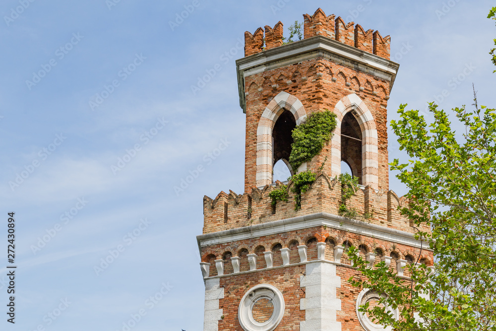 Tower at the entrance of the Arsenale in Vencie Italy, ovegrwon with climbers