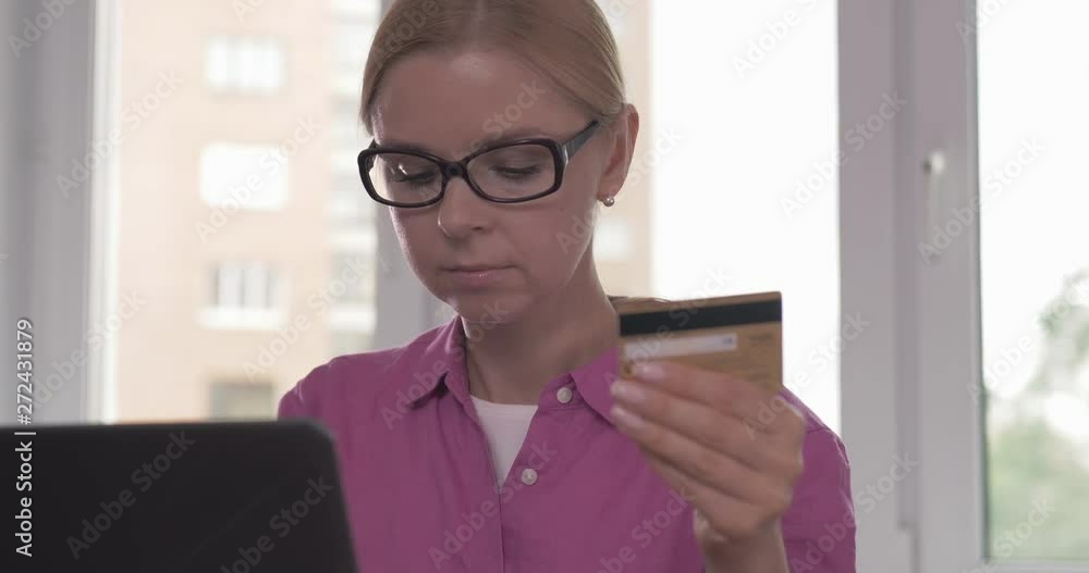 Portrait of smiling woman holding credit card in her hand while shopping online Portrait of smiling woman holding credit card in her hand while shopping online