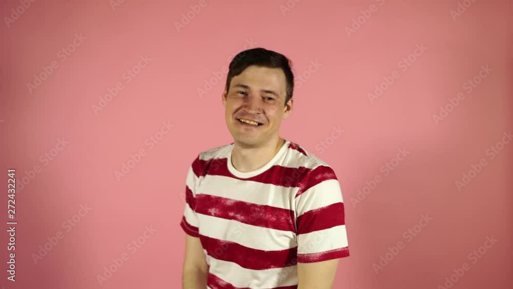 crazy man jumps and smiles, showing his hands on himself, on a pink background crazy man jumps and smiles, showing his hands on himself, on a pink background