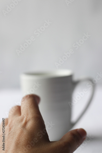 Coffee addiction, white coffee mug and hand