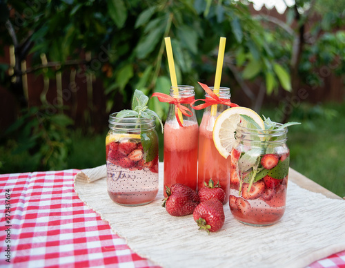 Strawberry and mint infused detox water. strawberry lemonade with ice and mint as summer refreshing drink in jars. Cold soft drinks with fruit.
