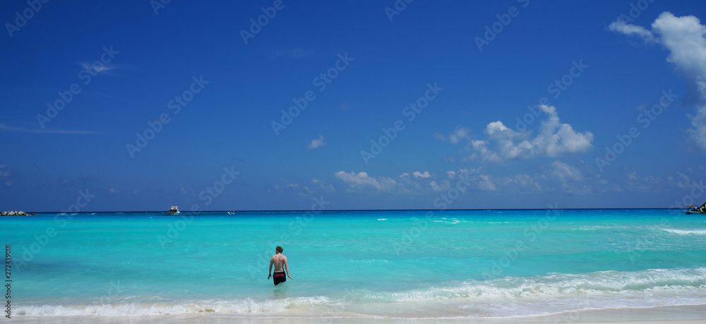 Man swimming in Caribbean sea, Cancun beach, Mexico.