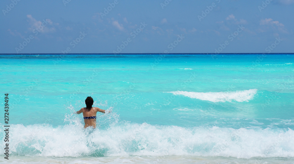 Woman swimming in Caribbean sea with a beautiful turquoise color. Vacation in Cancun, Mexico.