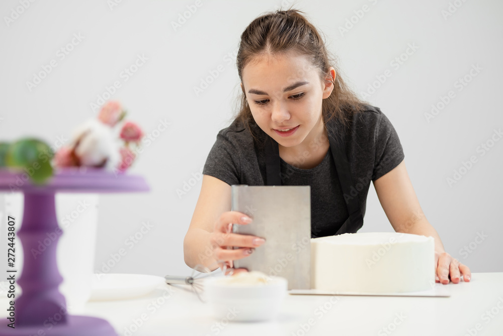 White smooth cylindrical cake blank. The confectioner creates the shape of a pastry spatula. White smooth cylindrical cake blank. The confectioner creates the shape of a pastry spatula.
