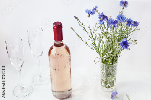 bottle of rose wine on a white background with glasses and strawberries