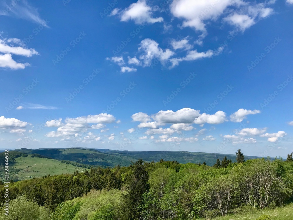 Scenic hike to the Wasserkuppe, the highest mountain of Bavaria's Rhön (Rhoen) region with its airfield and radar station (Radom) on a beautiful sunny summer day with a blue sky and white clouds