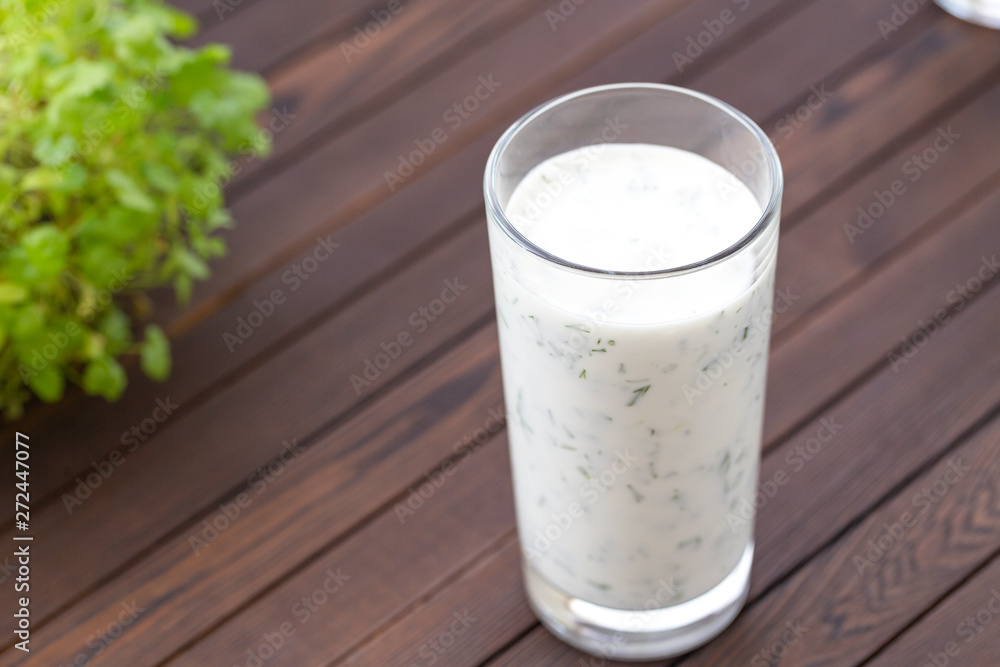 Fresh homemade yogurt (kefir, ayran) in glass with herbs. Ayran, homemade yogurt drink with herbs and cucumbers - healthy summer refreshing cold drink. Probiotic fermented dairy drink. Healthy food. Fresh homemade yogurt (kefir, ayran) in glass with herbs. Ayran, homemade yogurt drink with herbs and cucumbers - healthy summer refreshing cold drink. Probiotic fermented dairy drink. Healthy food.