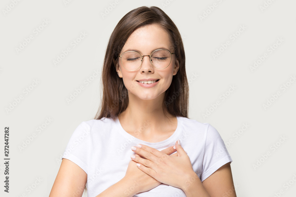 Headshot portrait gratitude woman closed eyes holding hands on chest Headshot portrait gratitude woman closed eyes holding hands on chest