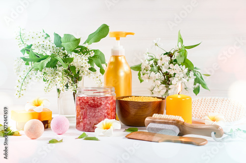 Spa and bath accessories with bath salts and beauty treatment products on white table. Wellness concept