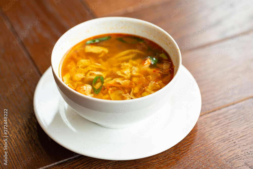 Asian noodle soup with chicken, vegetables and egg in a bowl on a wooden table. Asian noodle soup with chicken, vegetables and egg in a bowl on a wooden table.