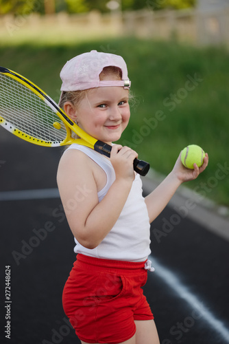 happy girl plays tennis on court outdoors © Aliaksei Lasevich