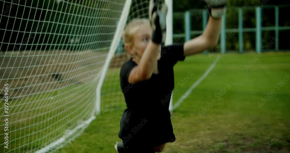 Young teenager girl soccer goalie diving to catch the ball during a match or practice. 4K UHD Young teenager girl soccer goalie diving to catch the ball during a match or practice. 4K UHD