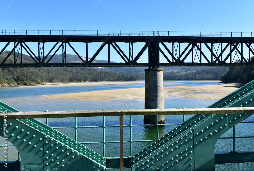 Fototapeta premium Beach with old and new train bridges. O Barqueiro, Spain.