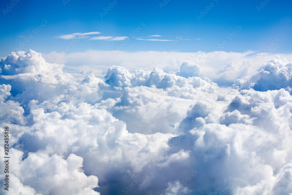 Fototapeta Białe chmury na tle niebieskiego nieba z bliska, chmury cumulus wysoko w lazurowym niebie, piękne anteny cloudscape widok z góry, słoneczny krajobraz nieba, jasne pochmurne niebo widok z samolotu, miejsce