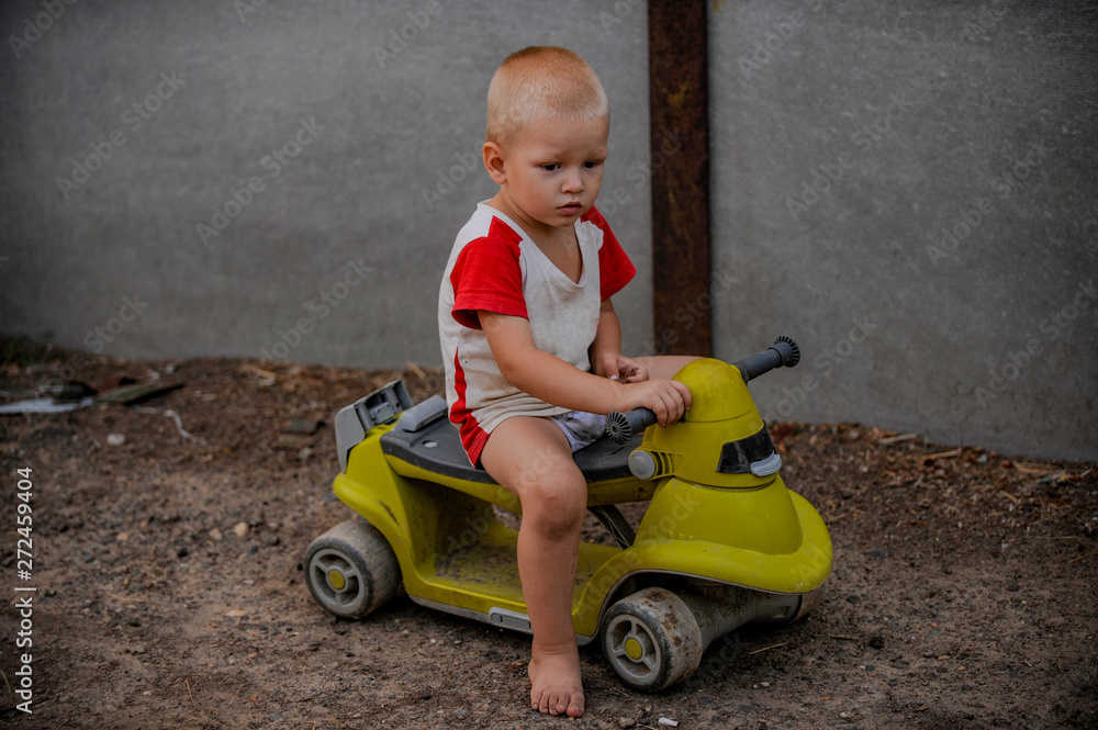 Rustic boy in T-shirt play in farmyard on background of sunset. child is happy in village on vacation Rustic boy in T-shirt play in farmyard on background of sunset. child is happy in village on vacation