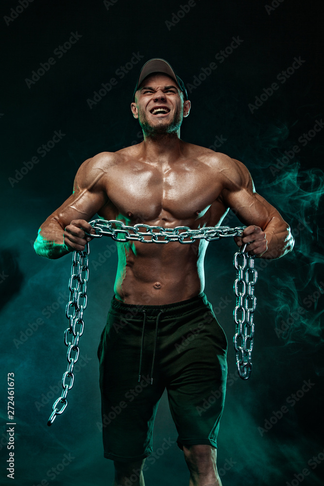 Muscular fitness sports man, atlete with chains in fitness gym.