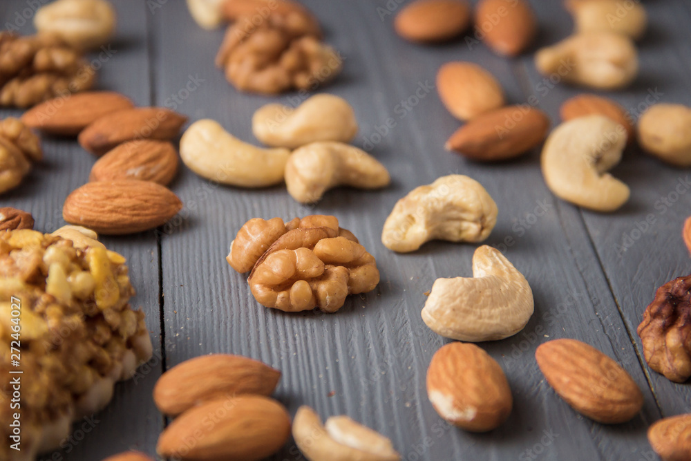 Assortment of nuts on gray wooden table. Cashew, hazelnuts, walnuts, almonds. Assortment of nuts on gray wooden table. Cashew, hazelnuts, walnuts, almonds.