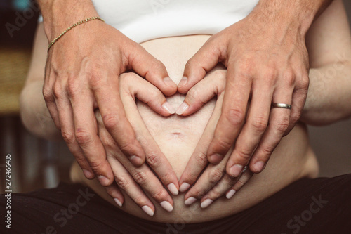 Man and woman hands on the pregnant belly
