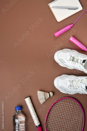 Sports equipment. Shuttlecock and badminton racket, skipping rope,  sneakers, pen and notepad on green background. Fitness and healthy  lifestyle concept. Flat lay, top view, copy space Stock Photo