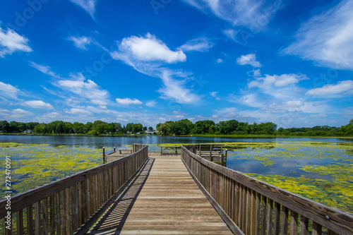 wooden bridge over lake blue skies