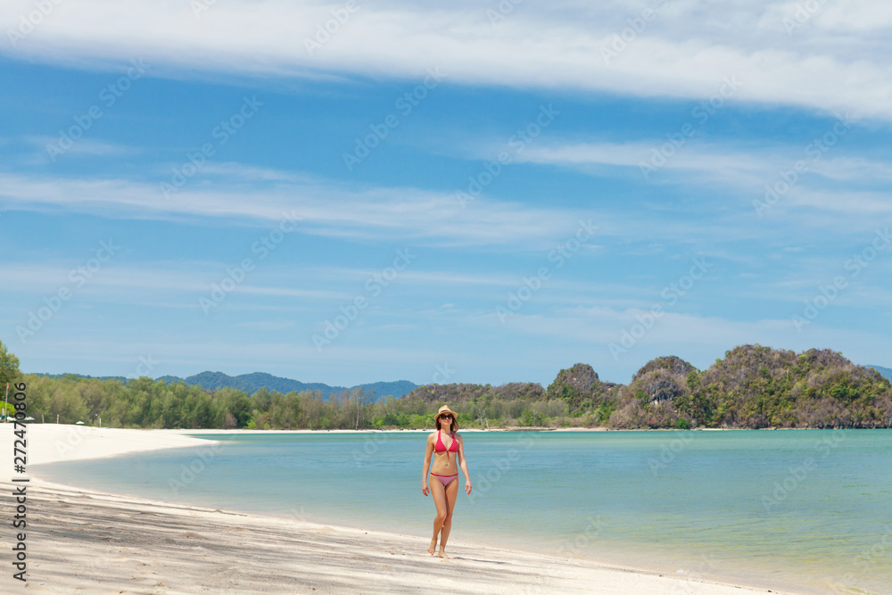 Obraz premium Young attractive woman walking on the sea beach