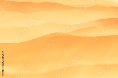 Closeup of orange paper layers stack abstract art background. Blur sandy desert hills effect. Copy space.