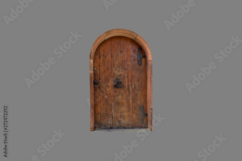 Isolated – old, wooden door with metal ornaments on a gray background.