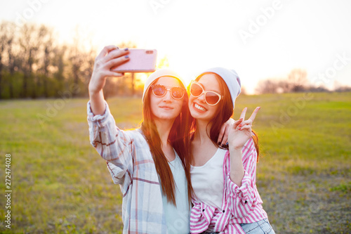 Two girls making selfie at sunset. Best friends