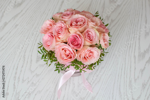 Beautiful round bouquet of pink roses on a white wooden background. Gift for holiday, birthday, Wedding, Mother's Day, Valentine's day, Women's Day. Top view. 