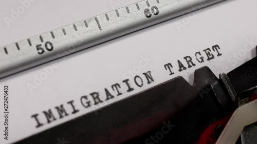 Immigration. A goverment decision to set the level of international movement of people across borders into another country, Typing IMMIGRATION TARGET on an old manual typwriter. photo