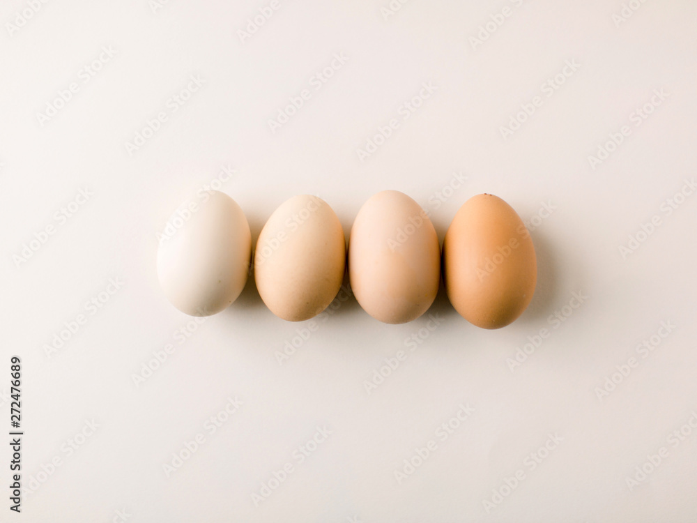 Four eggs on blush background of varying colors Four eggs on blush background of varying colors