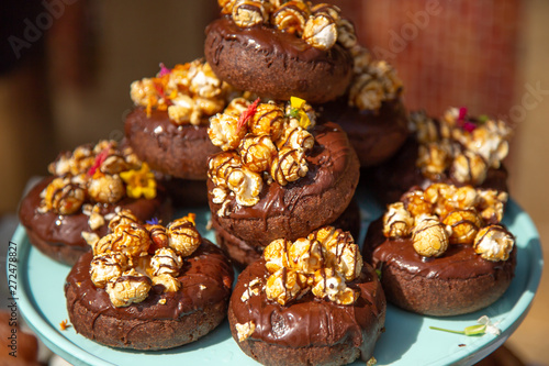 Several chocolate donuts with caramel popcorn topping