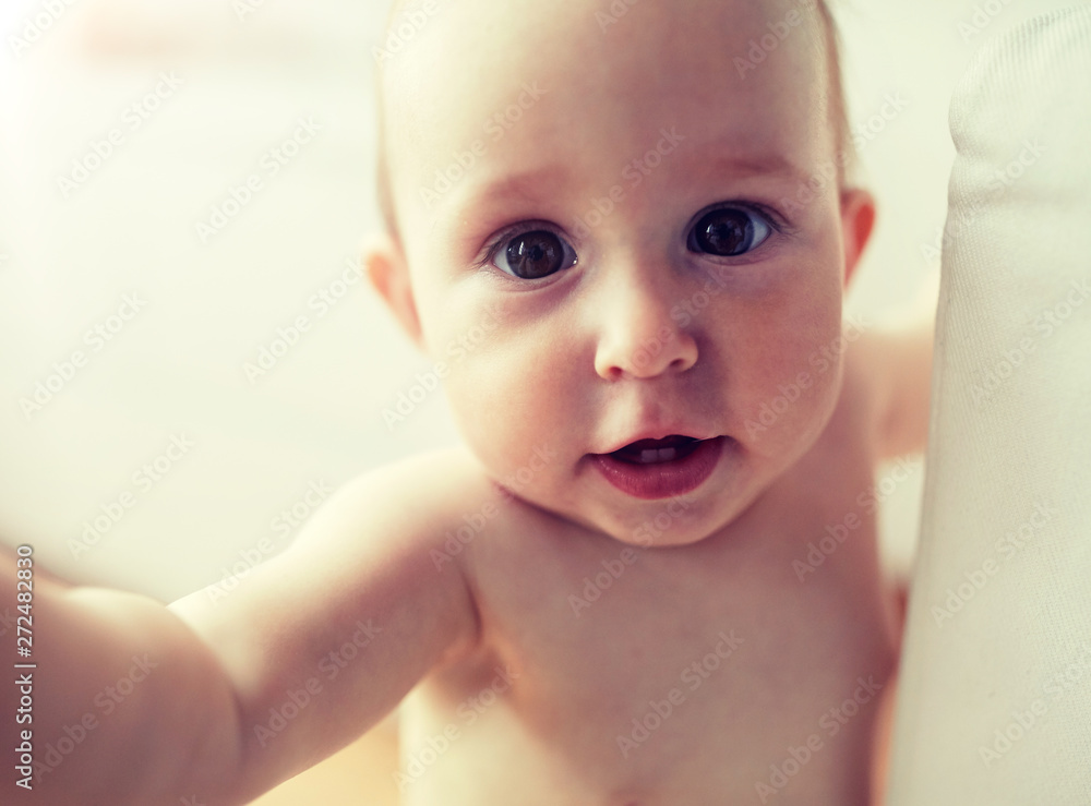 childhood, babyhood, emotions and people concept - close up of happy little baby boy or girl at home childhood, babyhood, emotions and people concept - close up of happy little baby boy or girl at home