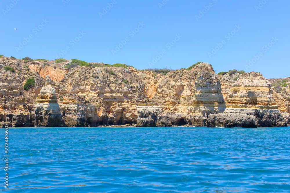 Panoramic landscape view of golden cliffs and emerald water in Ponta da Piedade, Lagos, Algarve, Portugal