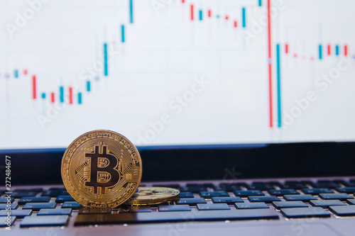 golden bitcoin on keyboard laptop with forex trading graph background