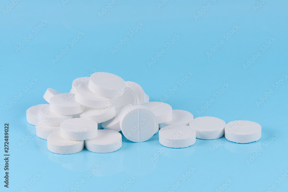 White pills on a blue background. White pills on a blue background.