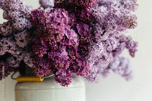 Awesome purple bouquet of lilac flowers in a stylish vase on a white background