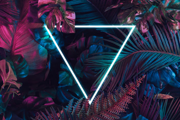 Creative fluorescent color layout made of tropical leaves. Flat lay neon colors. Nature concept.