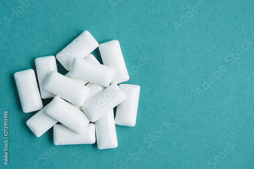 top view of heap of chewing gums on blue background, copy space photo