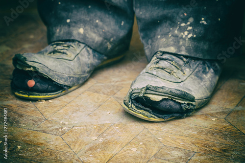 Old torn boots on the man's feet photo