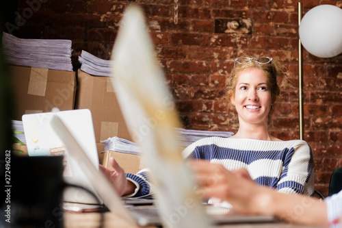 Portrait of woman talking to co-workers at office photo