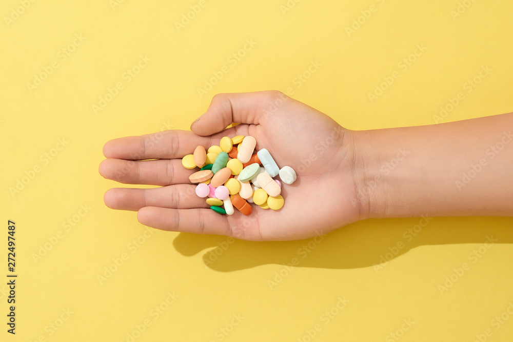 Multiple colors pills in hand Multiple colors pills in hand