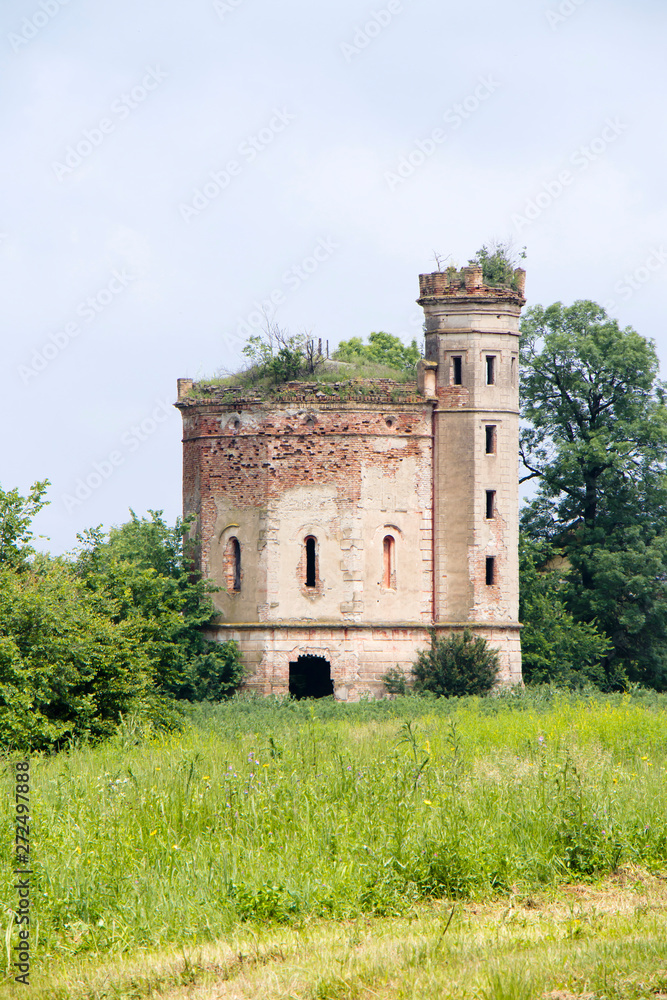 Small ruined abandoned castle overgrown in vegetation