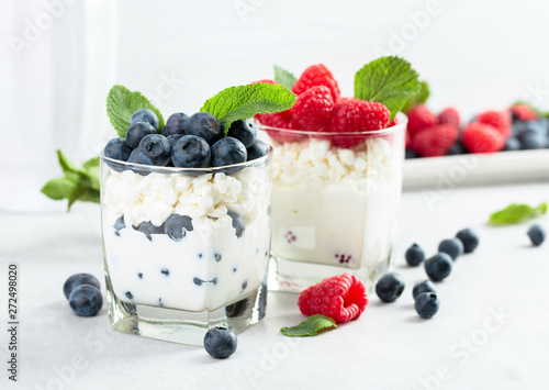 Cottage cheese with cream, raspberry and blueberry garnished with fresh mint.