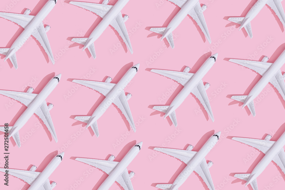 Creative composition made with passenger plane on pastel pink background. Summer travel or vacation pattern. - obrazy, fototapety, plakaty 